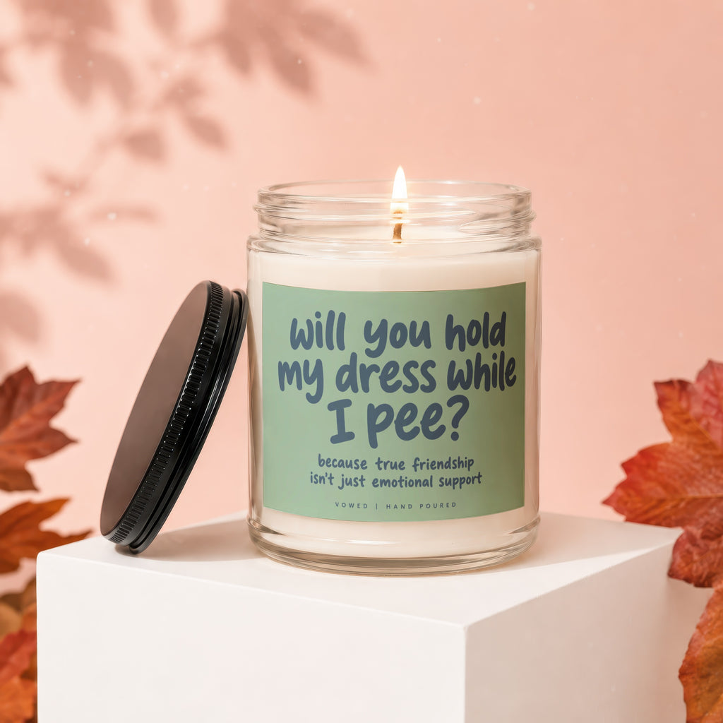 Candle with text "will you hold my dress while I pee?" and "Vowed".