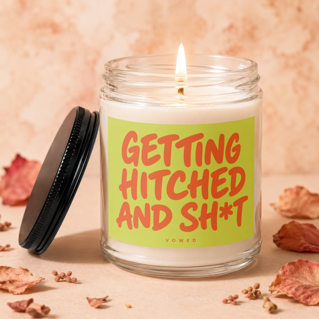 Lit candle in glass jar with "GETTING HITCHED AND SH*T" text on label