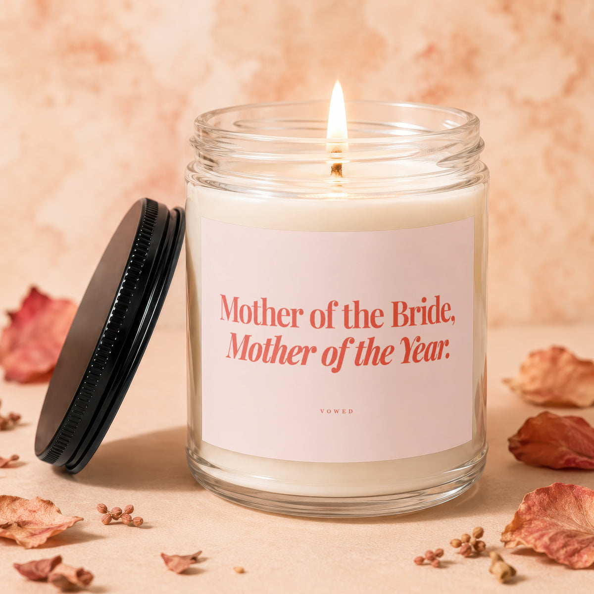 Glass candle with a lit wick and label reading "Mother of the Bride, Mother of the Year."