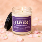 Candle with "I Say I Do Bridesmaid Wanted" label and lit wick.
