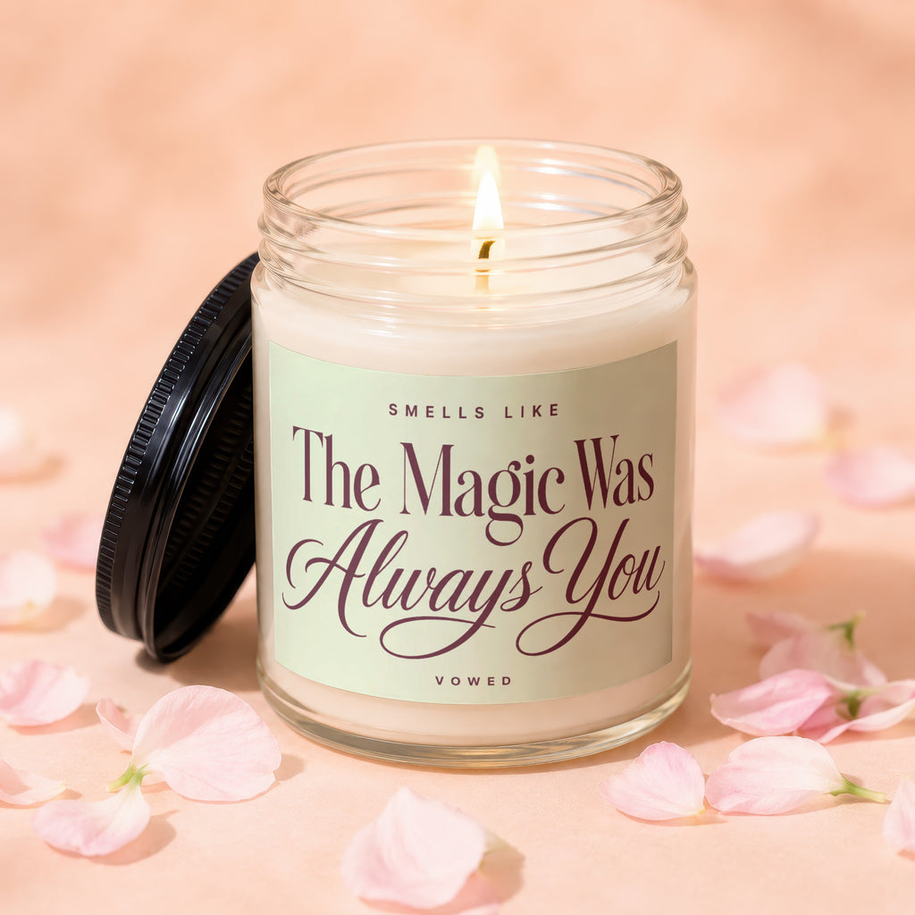Glass candle with lit wick, reads "Smells Like The Magic Was Always You".