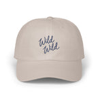 Light beige dad hat with blue cursive text embroidered reading Wild Wild.