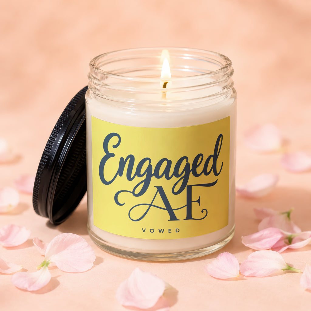 Candle with "Engaged AE VOWED" text on yellow label with pink petals