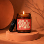 Amber jar candle with a lit flame and red label saying "Light This When My Son Is On Your Last Nerve".