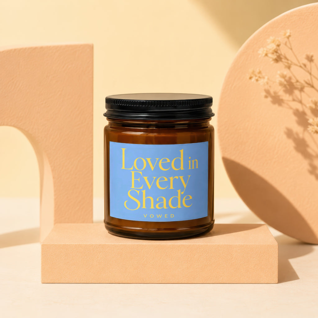 Brown glass candle with blue label text "Loved in Every Shade" and "vowed".