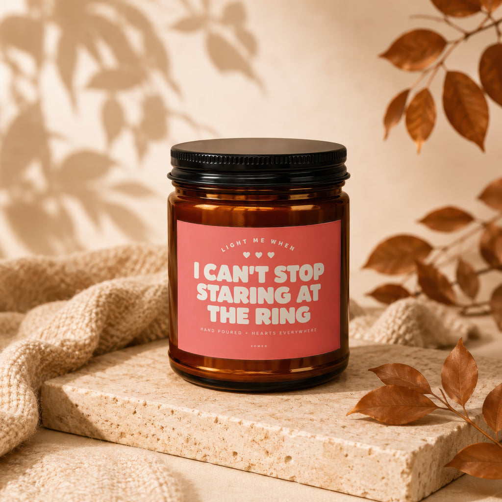 Amber candle with pink label reading "I Can't Stop Staring At The Ring."
