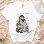 White t-shirt with "This Bride Bites" graphic featuring a bride looking in a mirror.