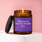 Amber jar candle with lit flame and purple label reading "Welcome to Your Pre-Wedding Era."
