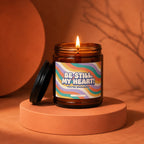 Amber jar candle with lit flame and a label reading "Be Still, My Heart! You're Engaged!".