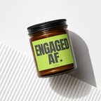 Amber candle in glass jar with black lid and bright green "ENGAGED AF." label.