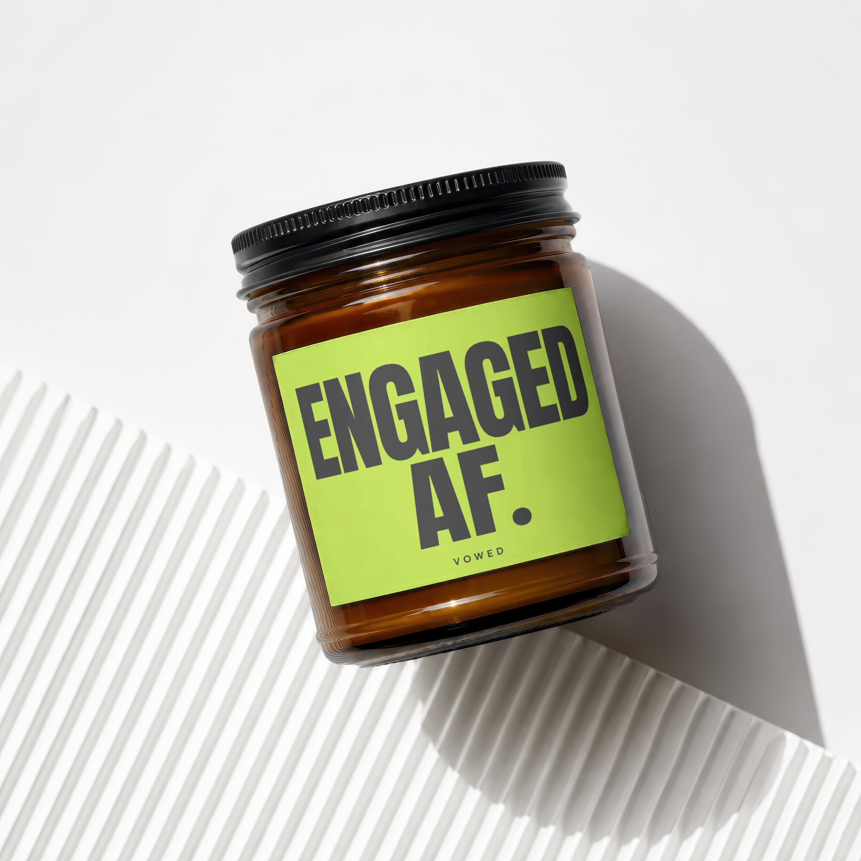 Amber candle in glass jar with black lid and bright green "ENGAGED AF." label.