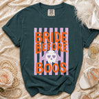 Green t-shirt with orange text "BRIDE BEFORE BOOS" and a skull graphic.