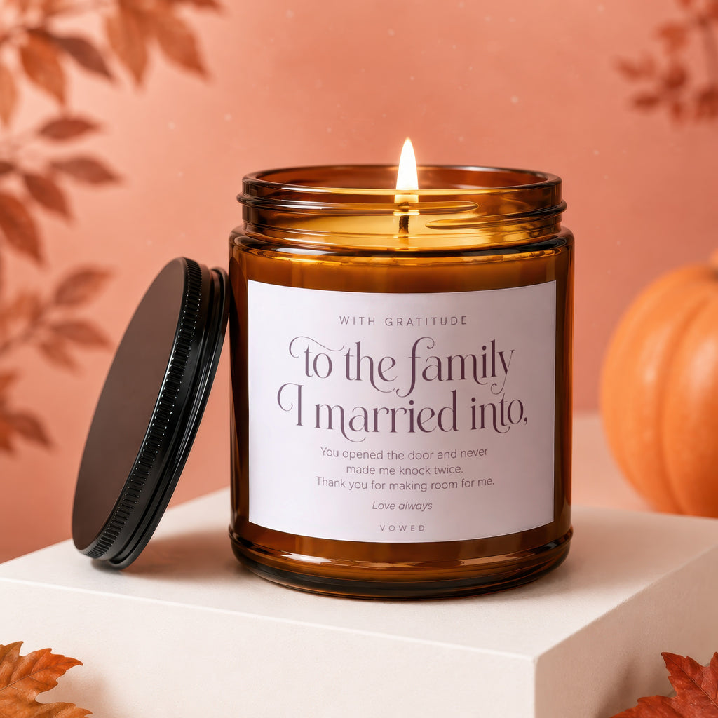 Amber candle with lit flame and label reading "To the family I married into."