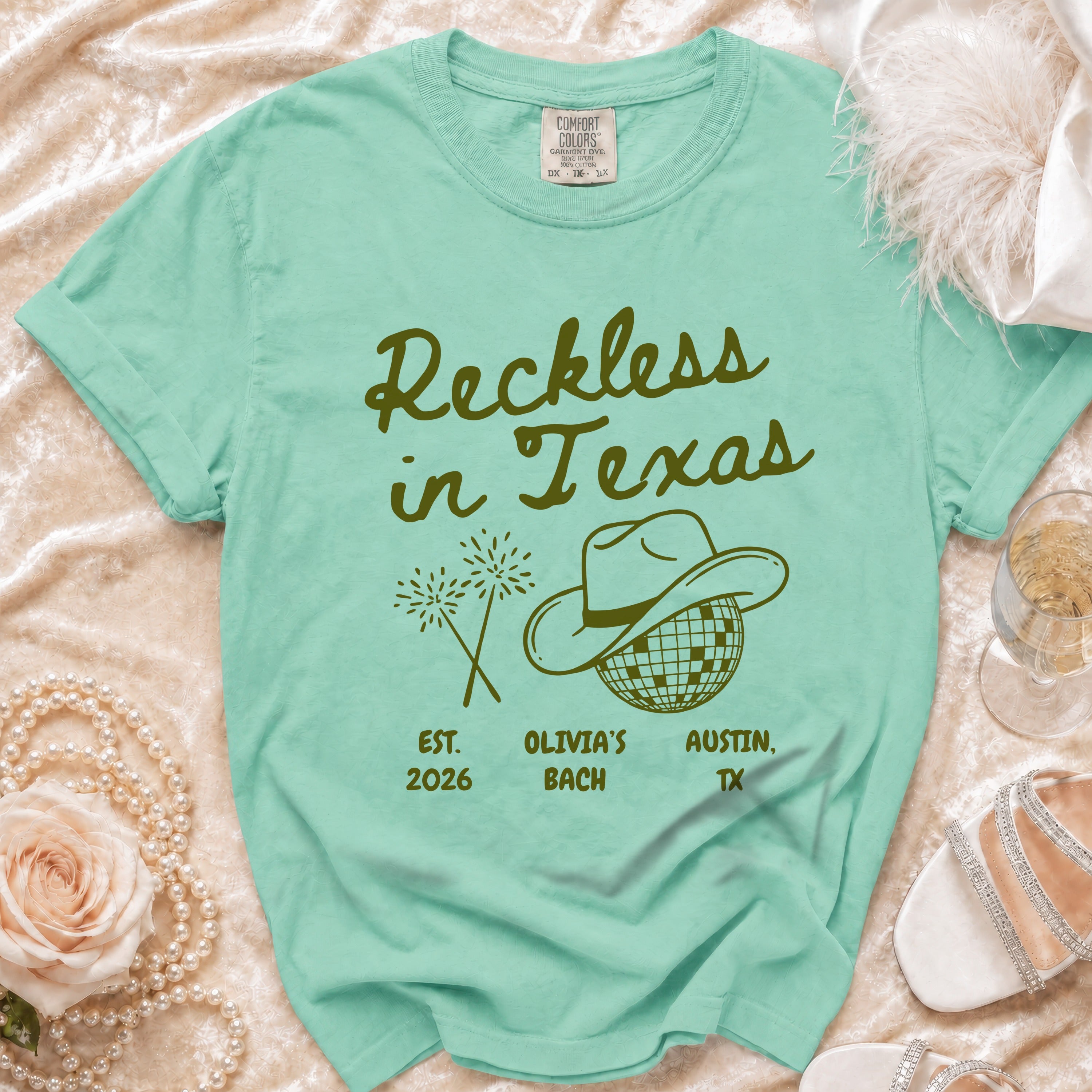Mint green t-shirt with "Reckless in Texas" and disco ball.