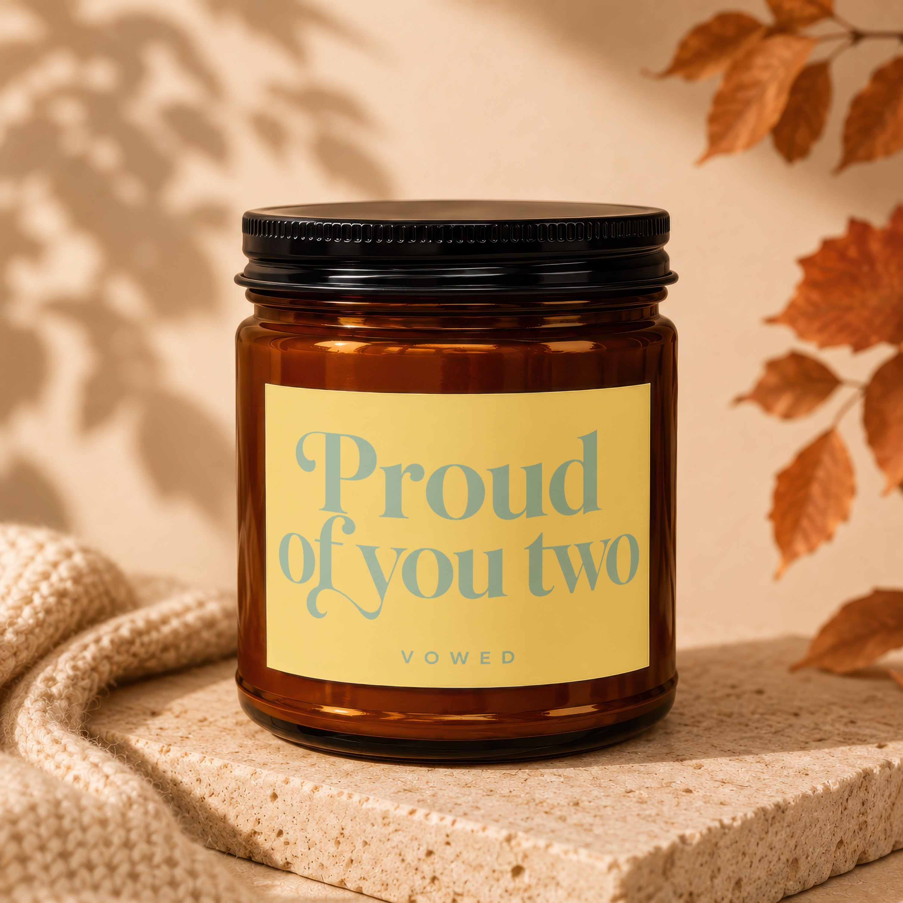 Brown glass candle with yellow label saying "Proud of you two" below "VOWED".
