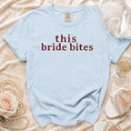 Light blue t-shirt with maroon text "this bride bites" and garment tag.