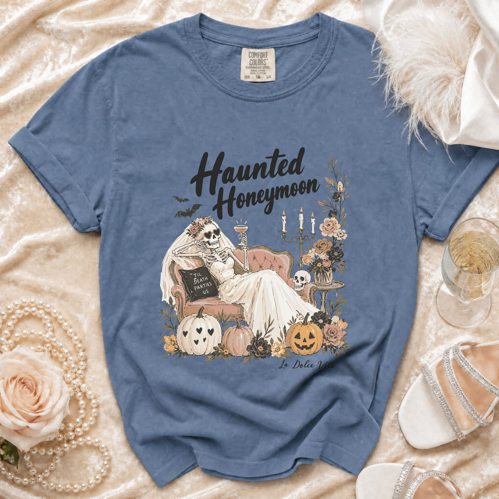Blue t-shirt with "Haunted Honeymoon" text, skeleton bride, pumpkins, and flowers.