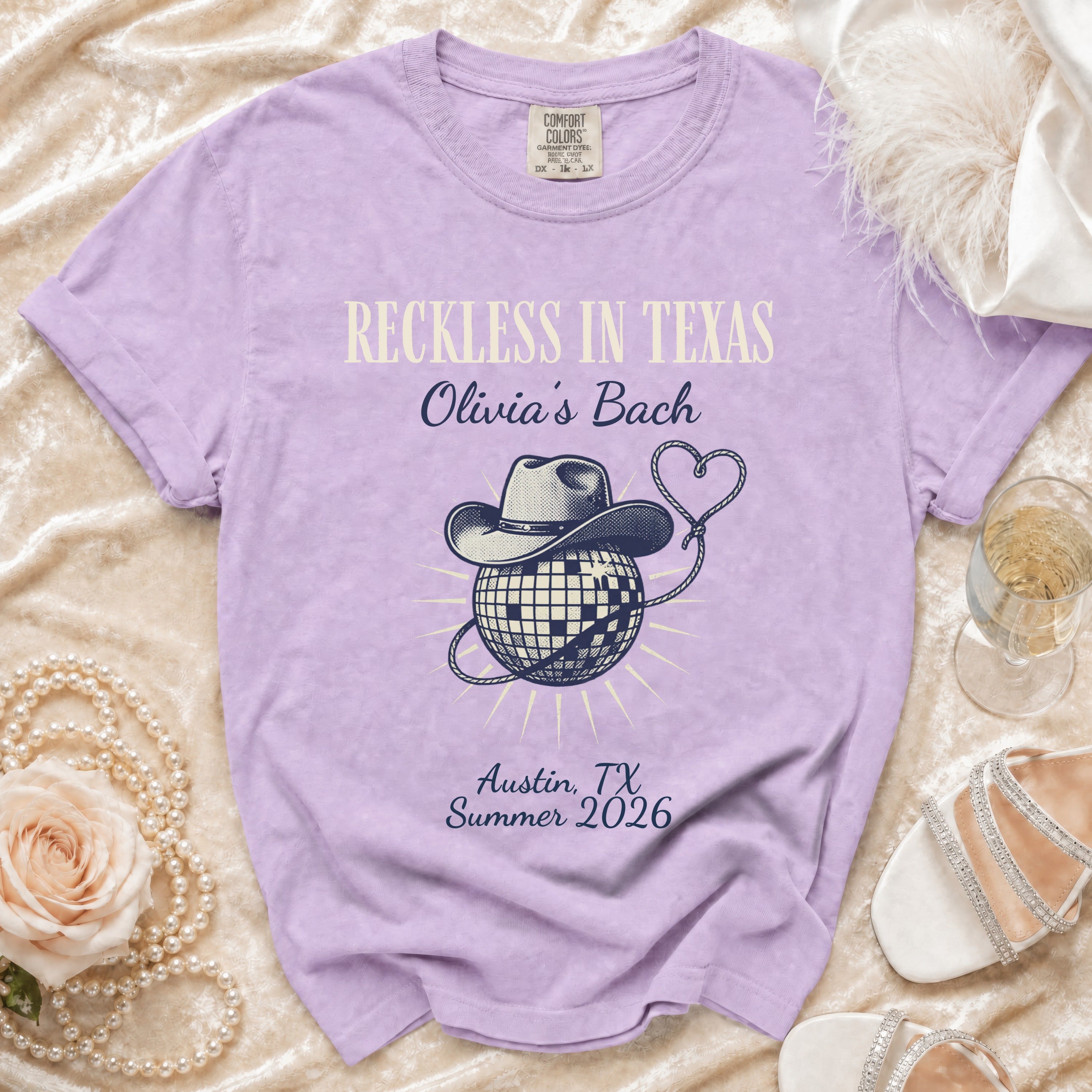 Purple t-shirt with "Reckless in Texas Olivia's Bach" and disco ball graphic.
