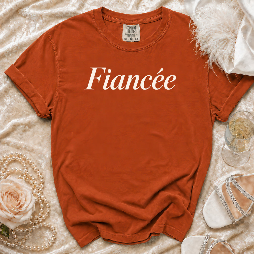 Orange t-shirt with "Fiancée" printed in white script, with wedding accessories.
