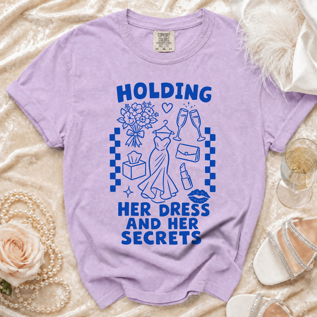 Purple t-shirt with "HOLDING HER DRESS AND HER SECRETS" text and graphics.