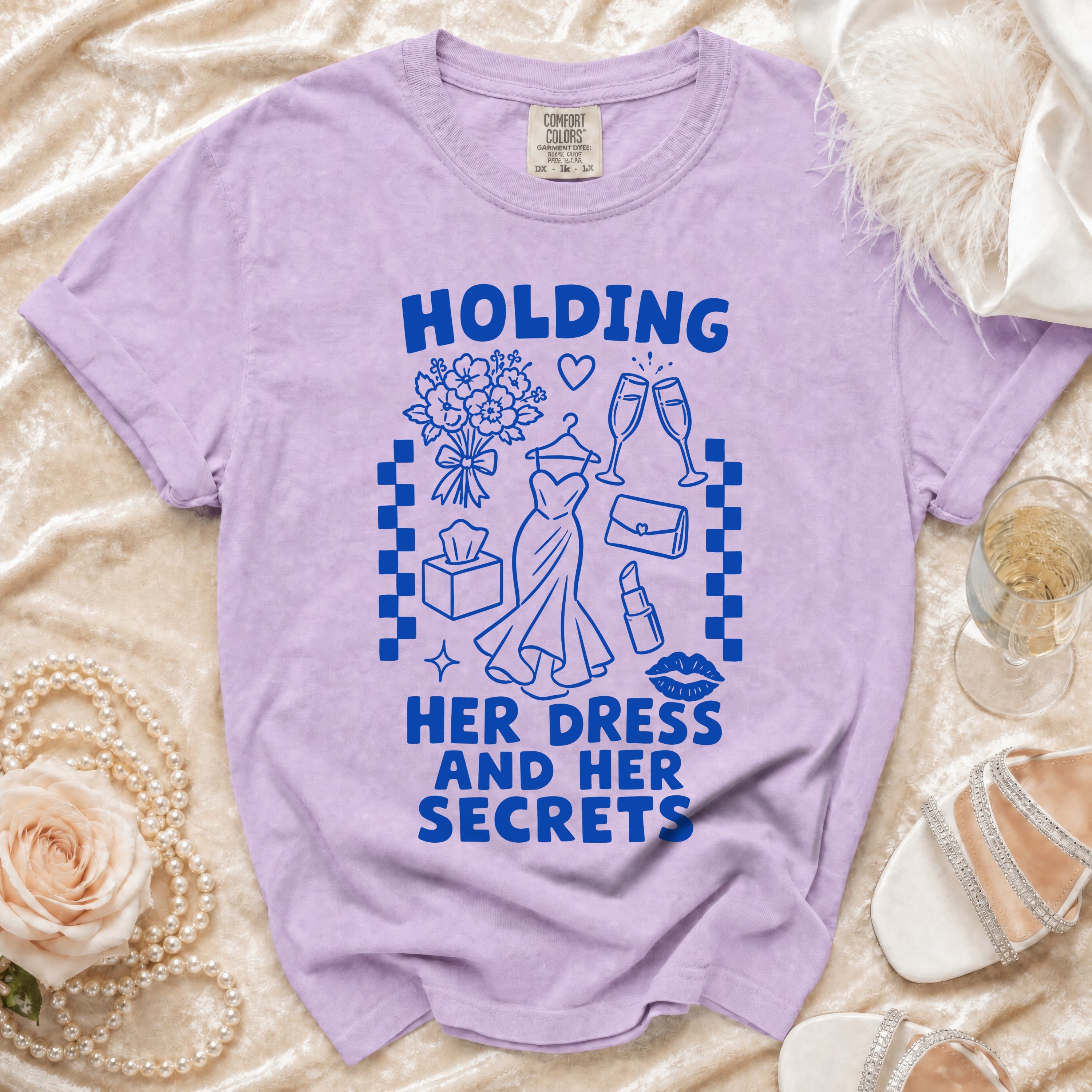 Purple t-shirt with "HOLDING HER DRESS AND HER SECRETS" text and graphics.