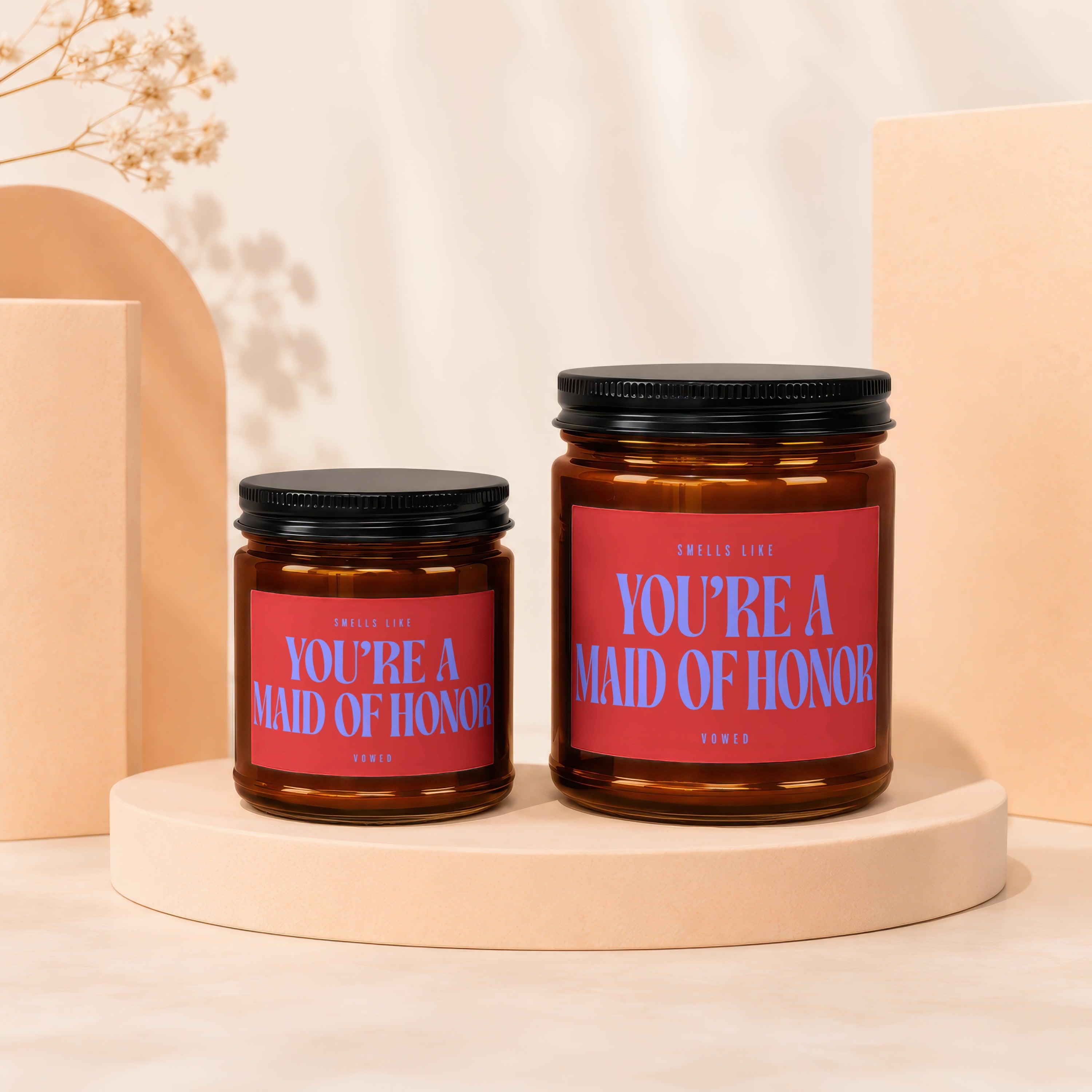 Two amber glass candles with red labels reading "You're a Maid of Honor."