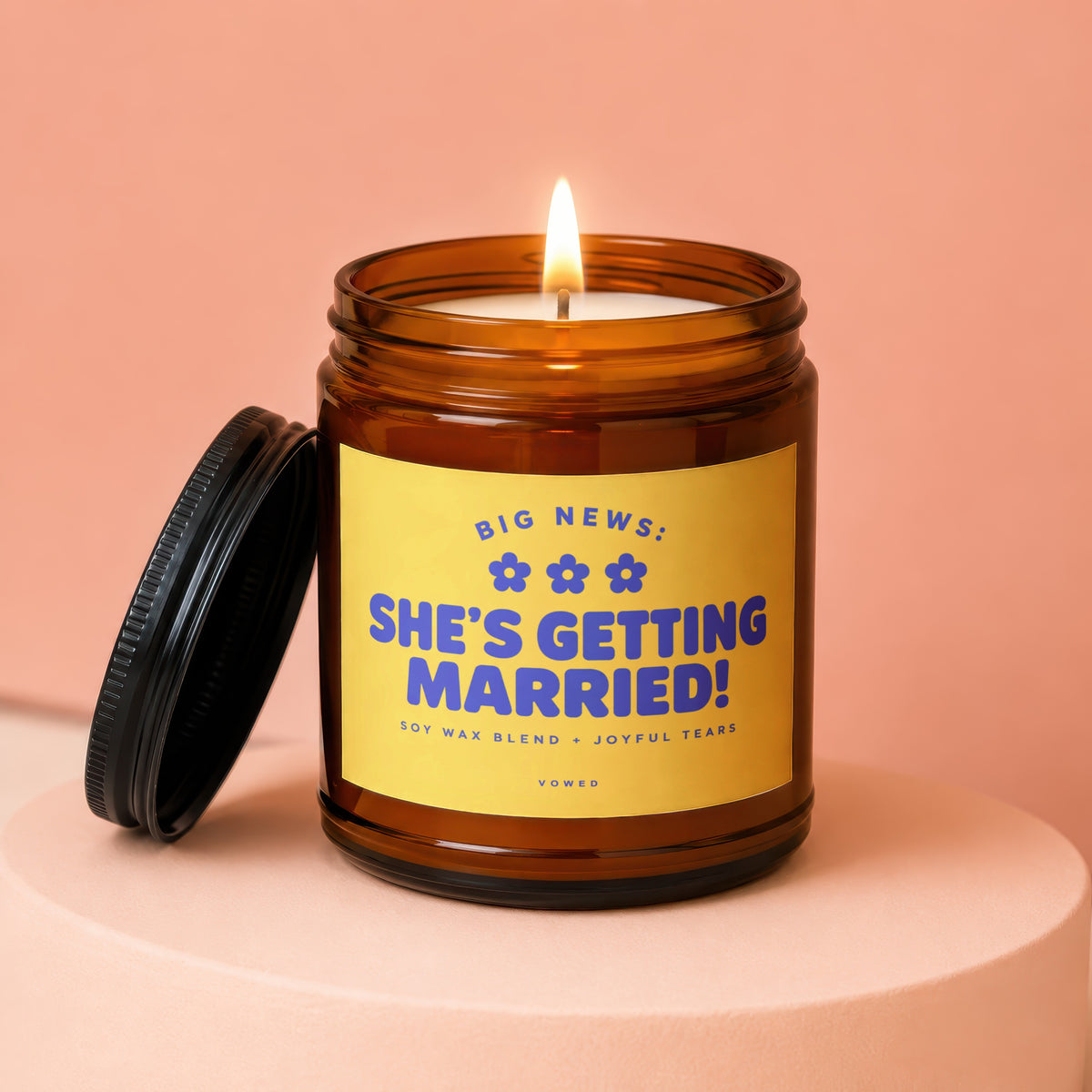 Amber jar candle with "She's Getting Married!" text and lit wick.