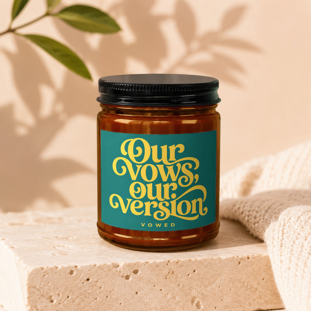 Amber jar candle with a teal label featuring yellow text "Our Vows, Our Version, Vowed".