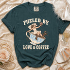 Teal t-shirt with bride in cowboy hat sitting in coffee cup, text "Fueled By Love & Coffee".