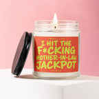 Lit candle in jar with black lid, reads "Smells like I hit the mother-in-law jackpot."