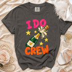 Dark grey t-shirt with "I DO CREW" text and champagne bottle graphic.