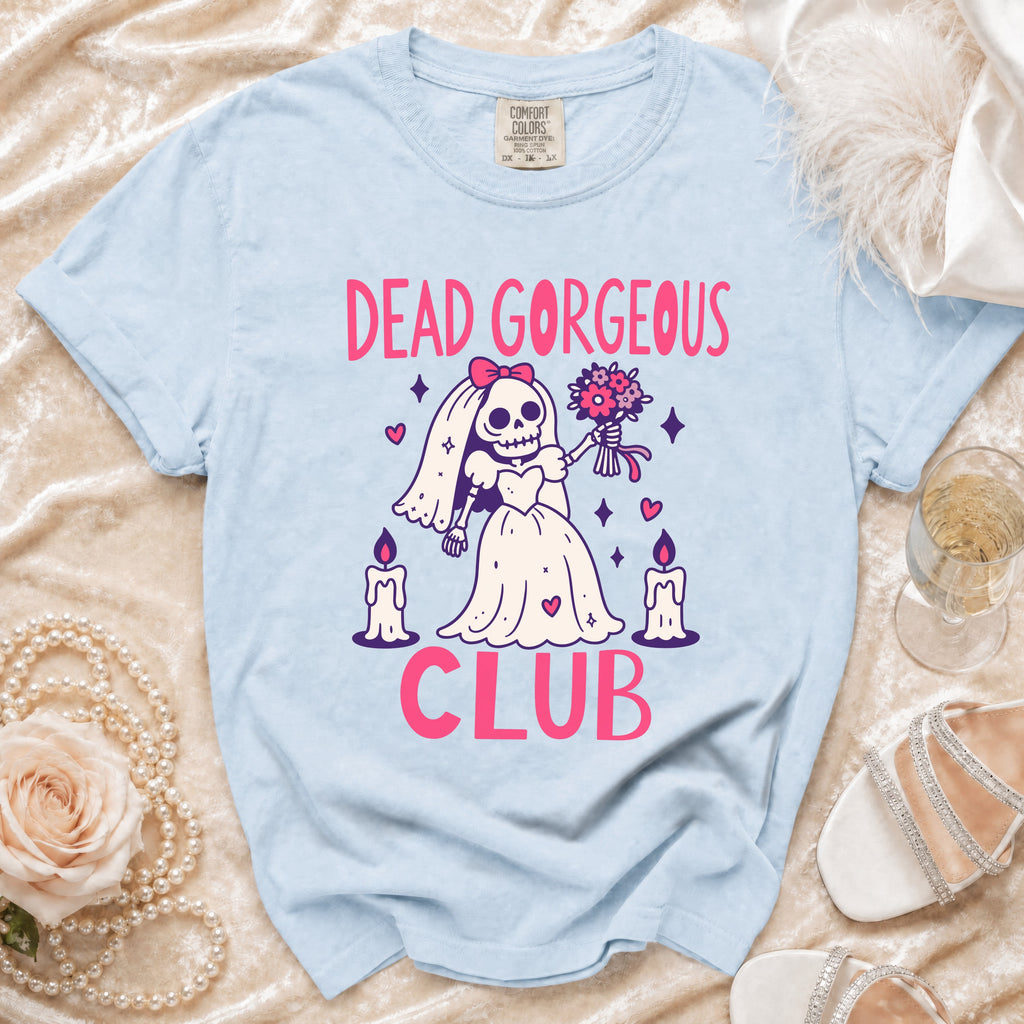 Light blue t-shirt with "Dead Gorgeous Club" graphic and skeleton bride illustration.