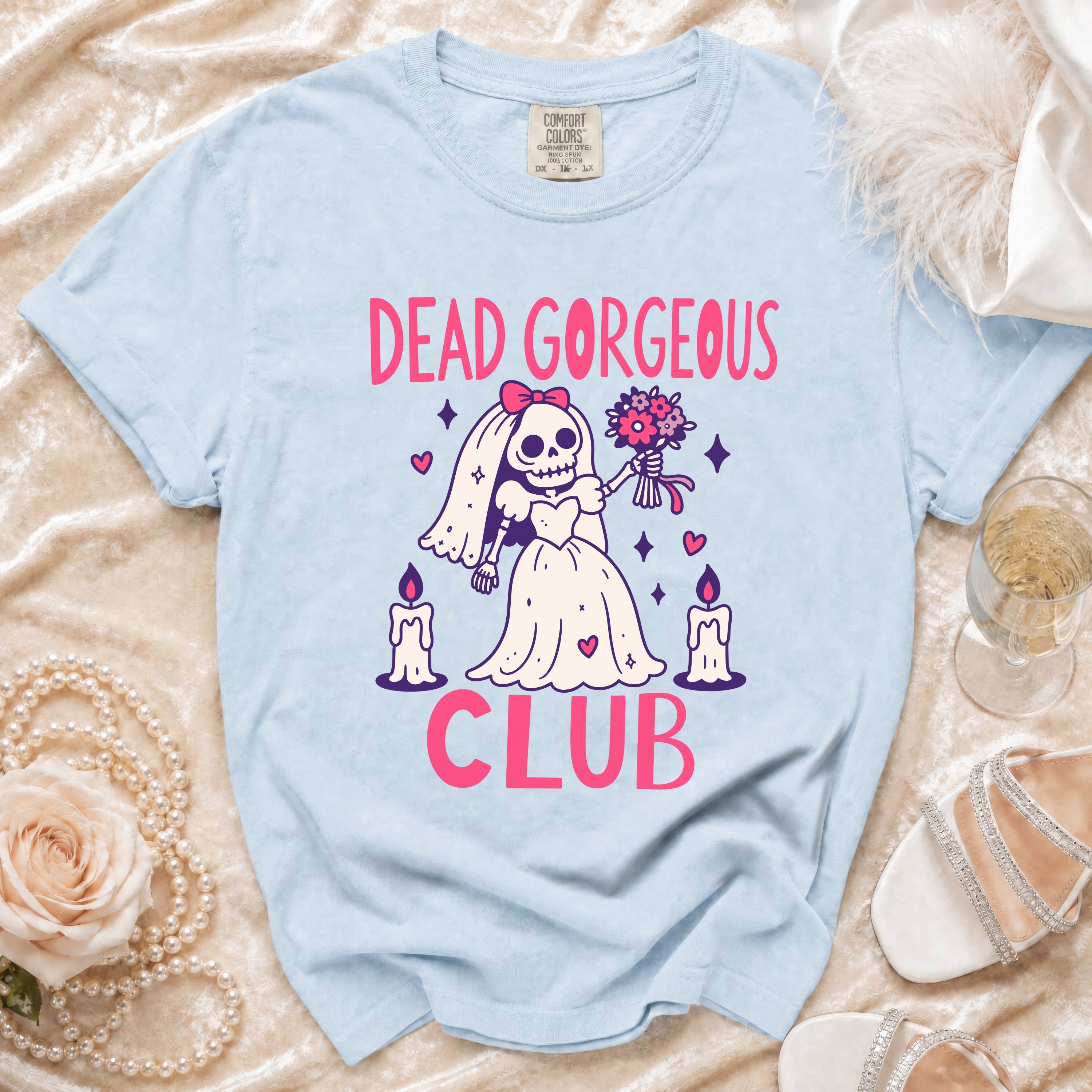 Light blue t-shirt with "Dead Gorgeous Club" graphic and skeleton bride illustration.