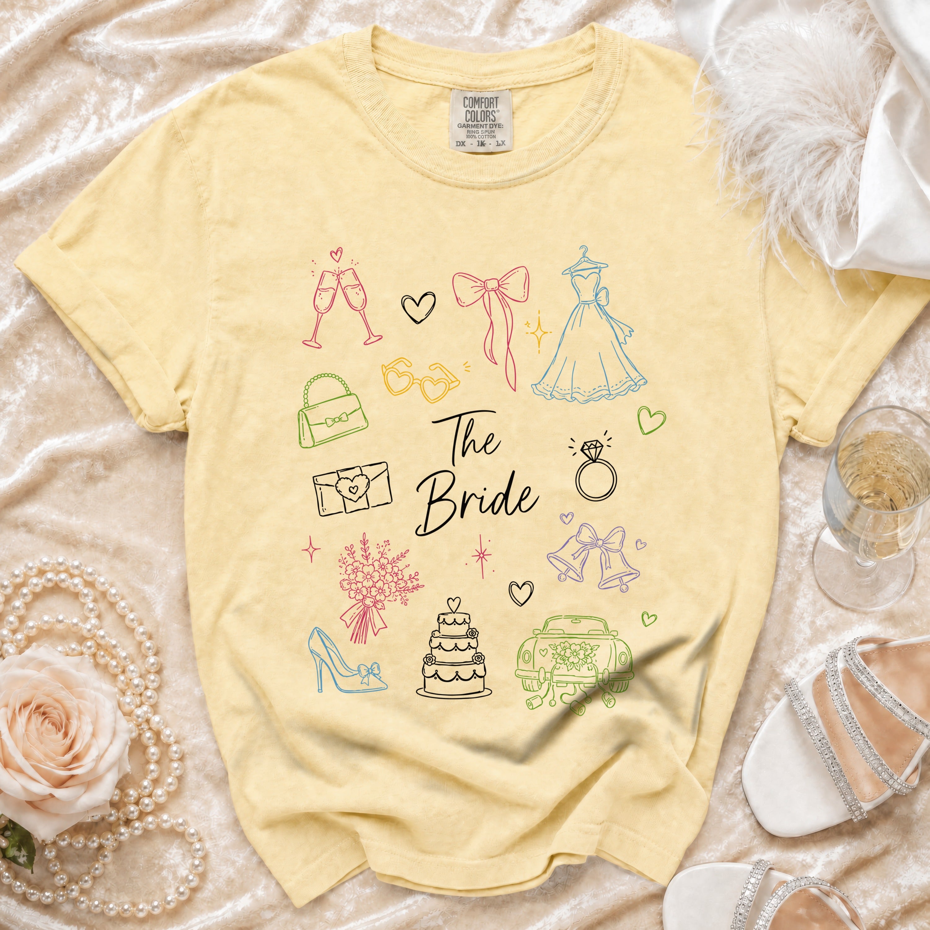 Yellow t-shirt with "The Bride" text and wedding-themed line drawings.
