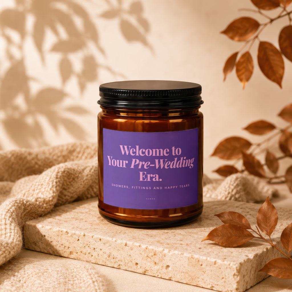 Amber candle with purple label reading "Welcome to Your Pre-Wedding Era."
