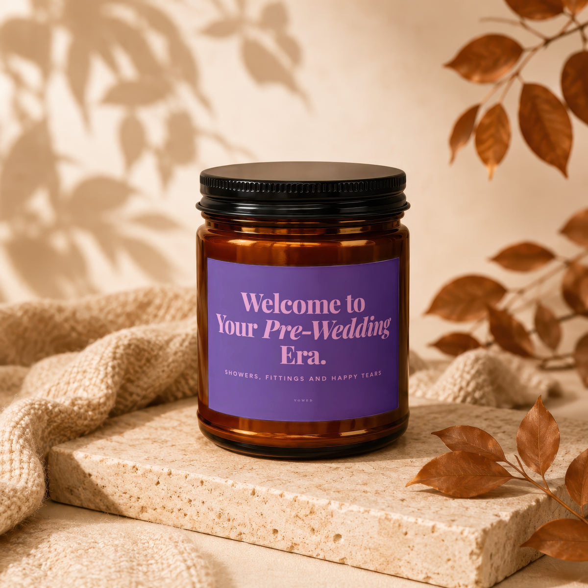 Amber candle with purple label reading "Welcome to Your Pre-Wedding Era."