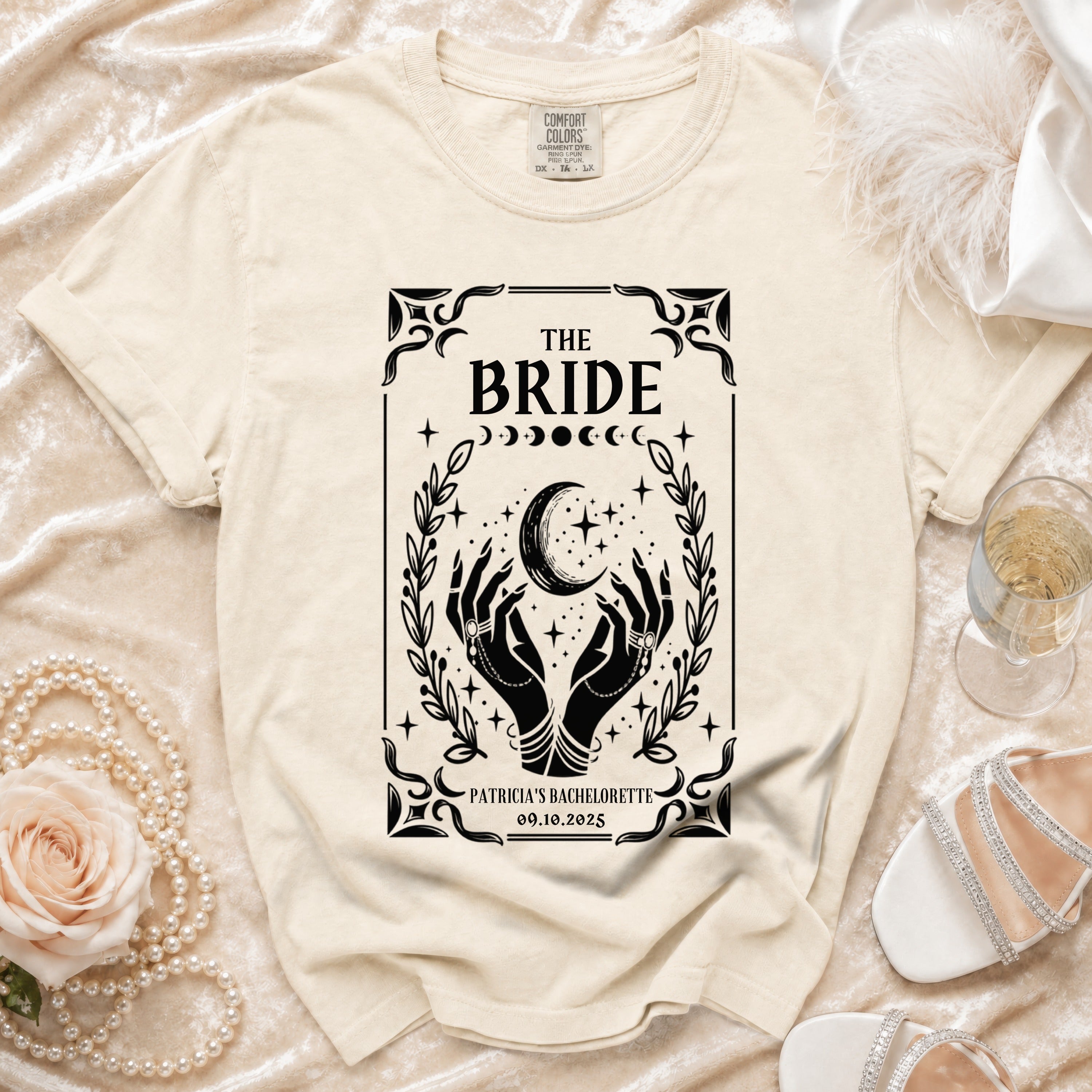 Cream t-shirt for "The Bride" with mystical hands, moon, and stars graphic.