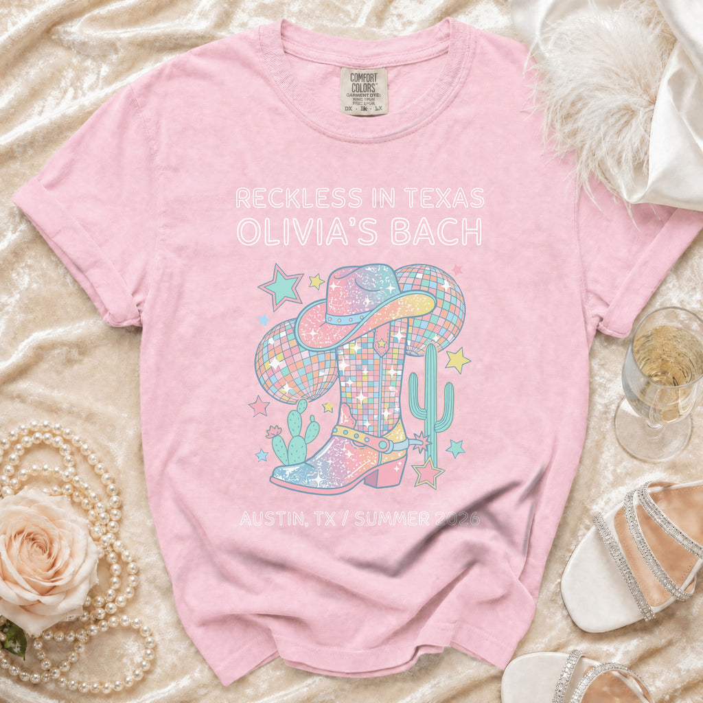 Pink t-shirt with "Reckless in Texas Olivia's Bach" and disco cowboy graphics.