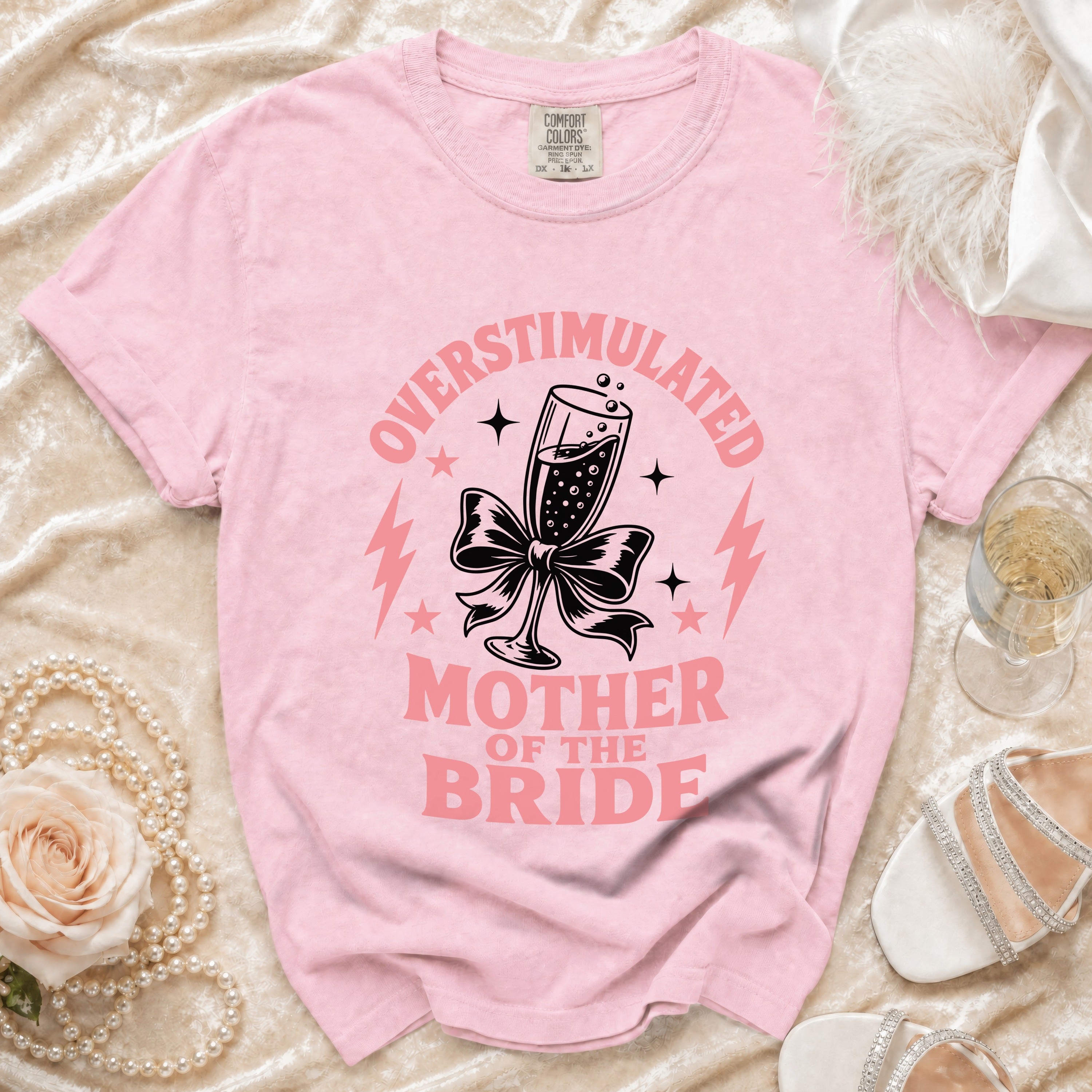 Pink t-shirt with "Overstimulated Mother of the Bride" text and champagne glass graphic.