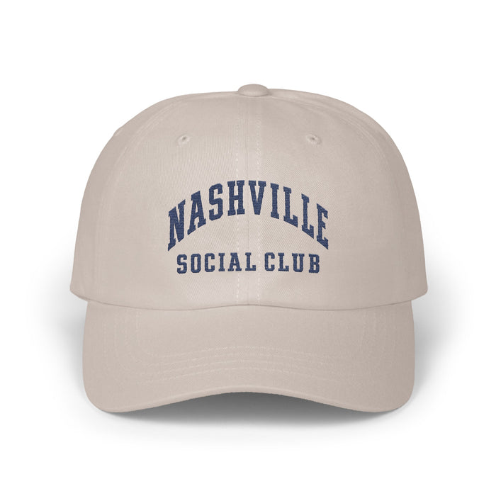 Beige baseball cap featuring embroidered blue text reading NASHVILLE SOCIAL CLUB on the front.