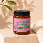 Amber jar candle with pink label reading "Smells Like The Yes Heard Round the Group Chat"