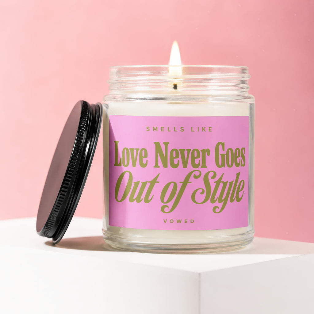 Candle with pink label that reads "Love Never Goes Out of Style"