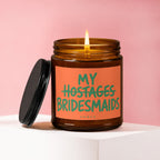 Amber jar candle with "MY BRIDESMAIDS" and crossed-out "HOSTAGES" text.