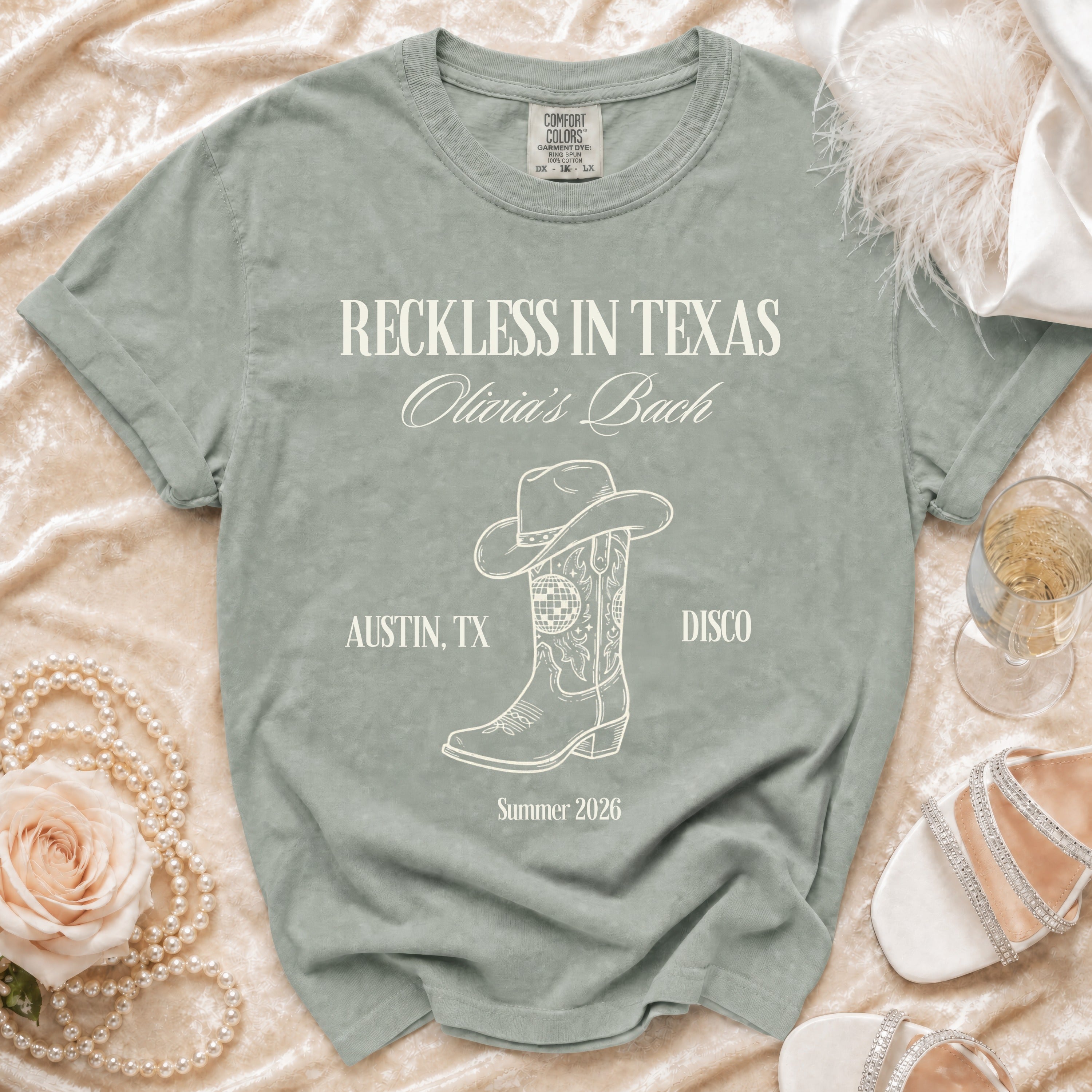 T-shirt with "Reckless in Texas Olivia's Bach" text, cowboy boot, and disco ball.