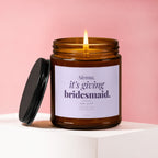 Amber candle burning with "Sienna, it's giving bridesmaid. say yes?" text.