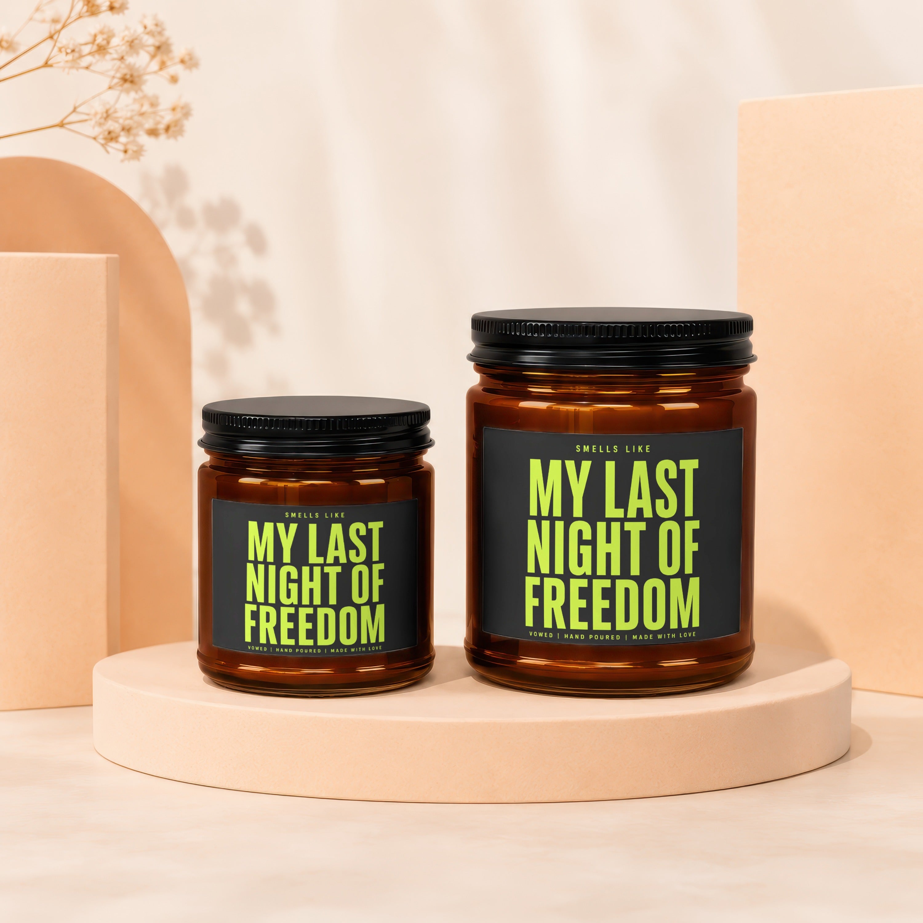 Two amber glass candles with black lids and black labels reading "My Last Night of Freedom".