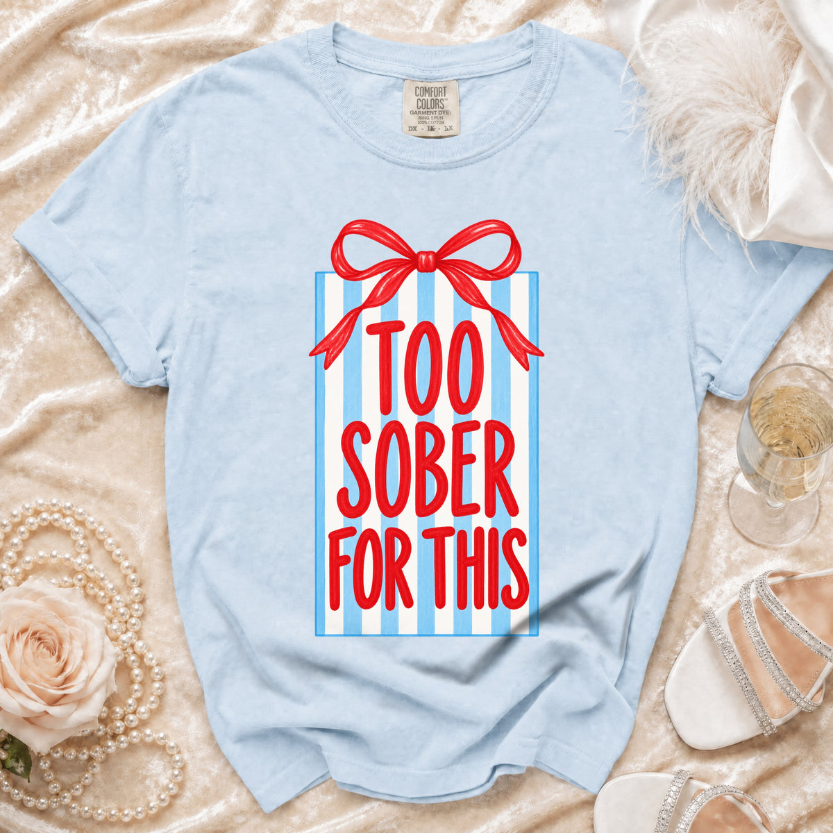 Light blue t-shirt with red text "TOO SOBER FOR THIS" on a gift box graphic.