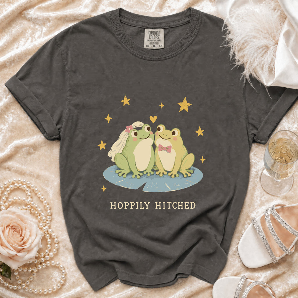 T-shirt with two cartoon frogs, one wearing a veil, and "Hoppily Hitched" text.