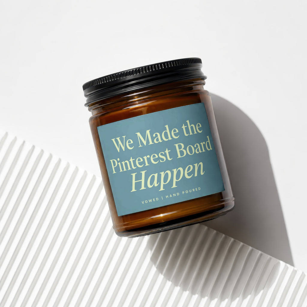 Amber glass candle with light blue label reading "We Made the Pinterest Board Happen".