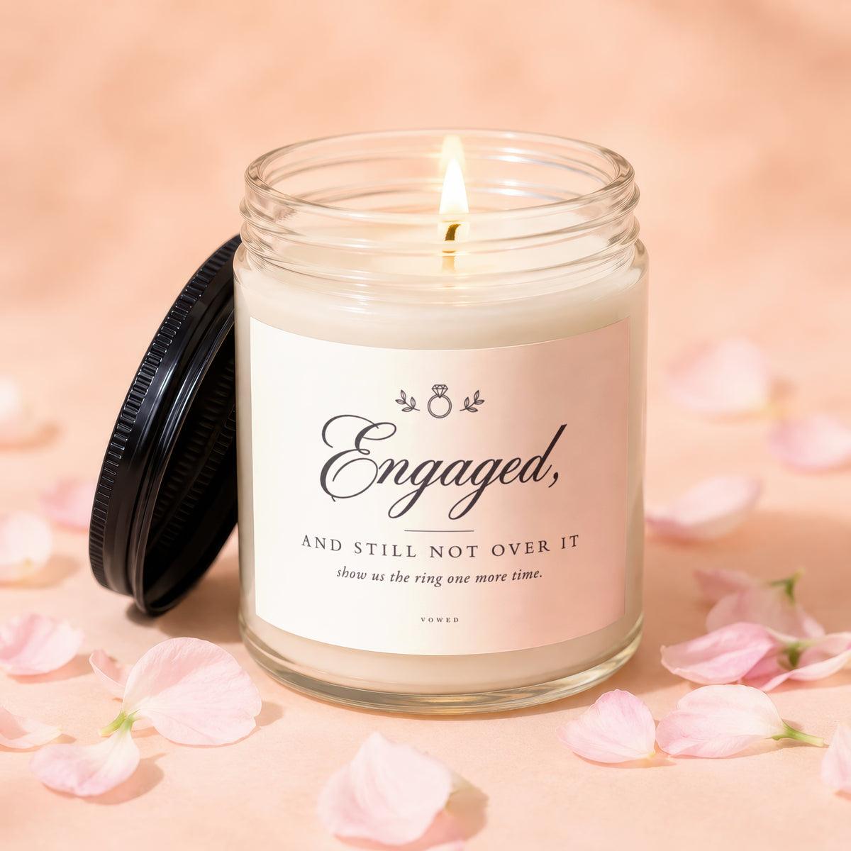 Engaged, and still not over it candle with ring icon and floral accents.